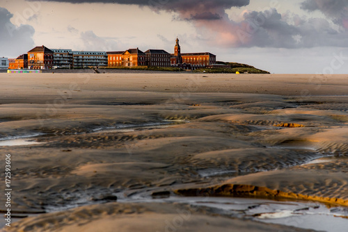Red and old brick buildings behind Berck beach at sunrise