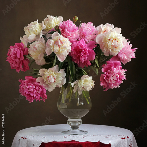 Lush bouquet of pink peonies in a vase on the table.