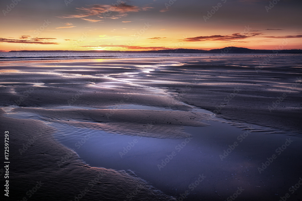 Puddles left on the shore after low tide at Aberavon beach in Port Talbot, South Wales, UK.
