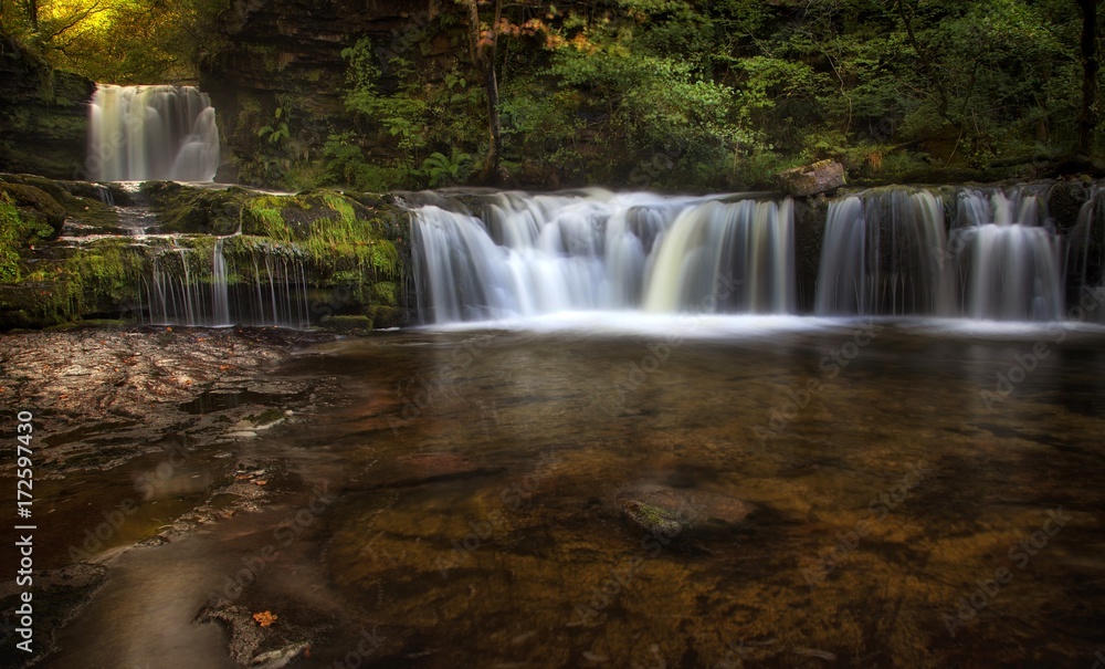 Obraz premium Sgwd Ddwli Isaf waterfalls on the river Neath, part of the waterfall country trail of falls, near Pontneddfechan in South Wales, UK. 