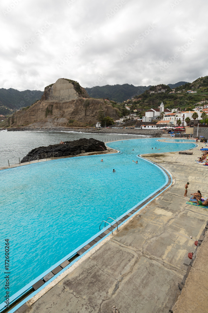 People rest by the Swimming Pool in Porto da Cruz on Medeira. Portugal