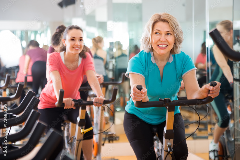 © caftor - active females riding stationary bicycles