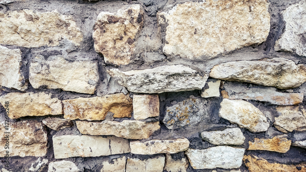 Stone old wall from huge blocks. Background of stones. The concept of reliability. The space between stones filled with cement. Stone old wall from huge blocks. Background of stones. The concept of reliability. The space between stones filled with cement.