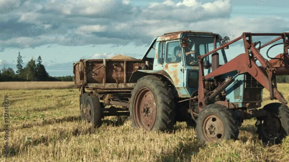 Old tractor and trailer filled with organic rye grains Old tractor and trailer filled with organic rye grains