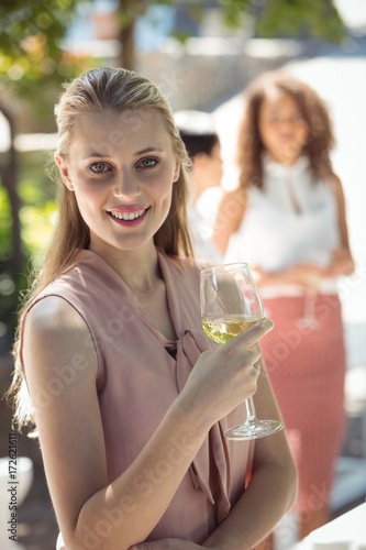 Smiling woman holding glass of wine in restaurant © wavebreak3