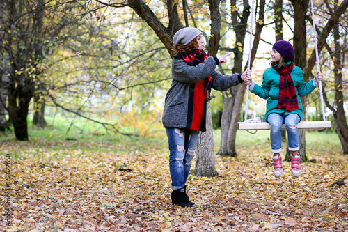 Mom and daughter on a walk in the autumn park