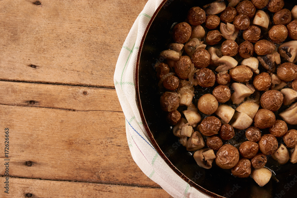 Fototapeta premium Fried potatoes and mushrooms in frying pan