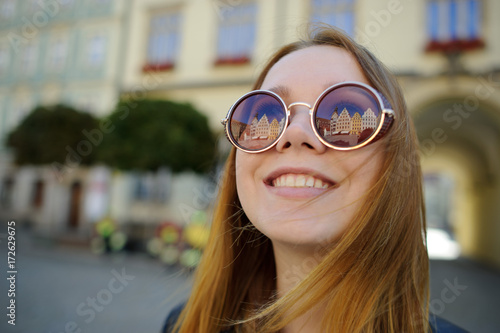 Portrait of a cheerful young girl against the backdrop of a beautiful building.