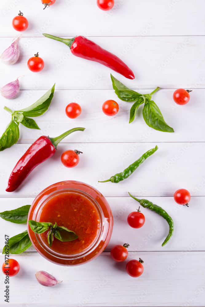 Spicy sweet tomato sauce with garlic, pepper and herbs in a glass jars. Spicy sweet tomato sauce with garlic, pepper and herbs in a glass jars.