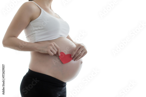 pregnant woman holding heart sign to one side