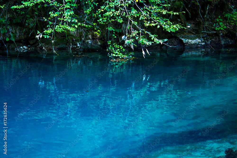 Amazing view of blue mountain lake like paradise, rock wall and colorful water .Scenery of Abkhazia paradise nature with awesome closeup perspective and fast stream. Amazing view of blue mountain lake like paradise, rock wall and colorful water .Scenery of Abkhazia paradise nature with awesome closeup perspective and fast stream.