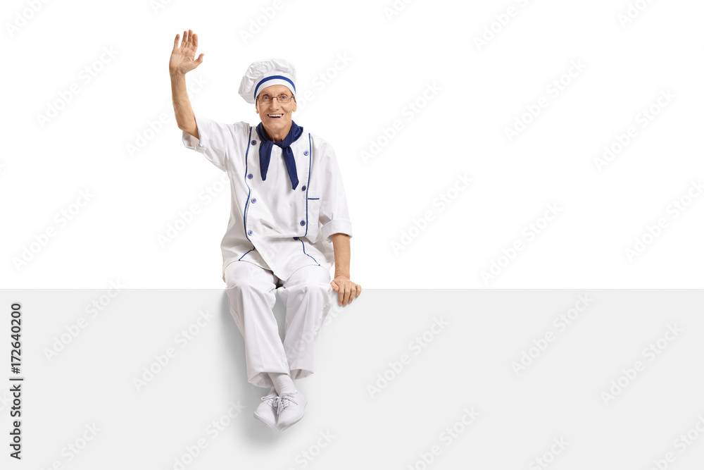 Chef sitting on a panel and waving at the camera Chef sitting on a panel and waving at the camera