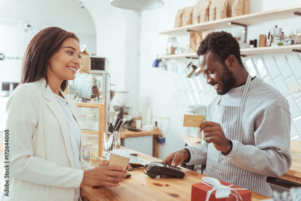Naklejka premium Smiling barista carrying out payment procedure