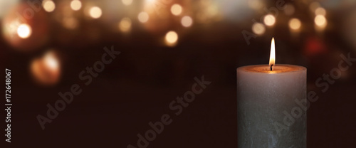 Burning candle with golden bokeh photo
