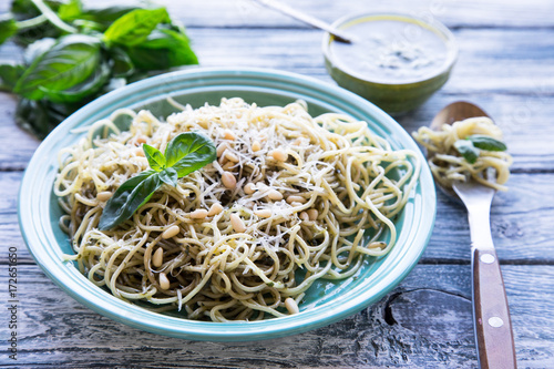 pasta spaghetti with homemade pesto sauce and basil leafs  wood background