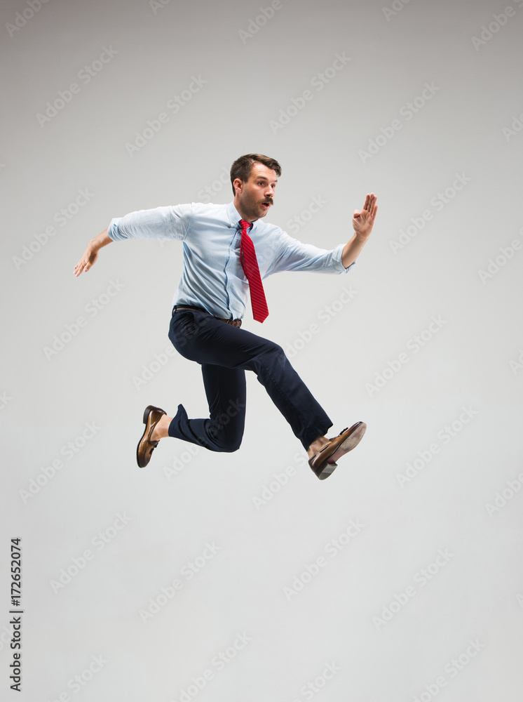 Businessman running on gray background