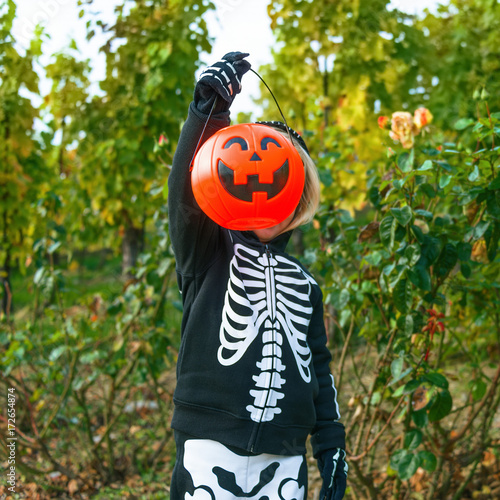 child showing Halloween pumpkin Jack O’Lantern basket