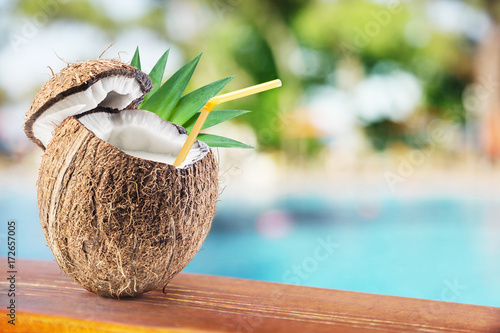 Coconut with cocnut milk on the bar table at the open-air cafe.