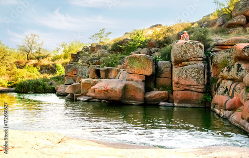 A beautiful Colorful view of Kamenka river, Tokovskoe settlement, Apostolove Raion, Dnipropetrovsk Oblast, Ukraine. A man sitting on top of a rock. Artistic style post processed photo. photo