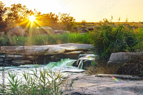 A beautifull view of waterfall in the rays of the setting sun on Kamenka river, Tokovskoe settlement, Apostolove Raion, Dnipropetrovsk Oblast, Ukraine. photo