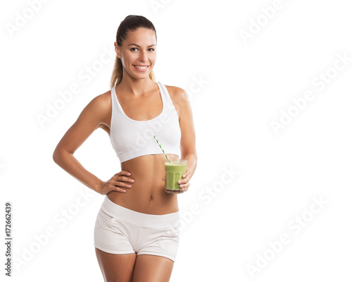 Fit, beautiful, young woman holding a healthy, green smoothie, isolated on white background