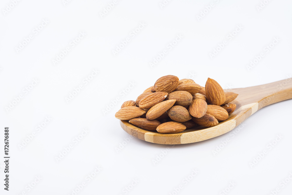 Almonds nuts in wooden ladle isolated on white background. Tasty medicine from nature. Almonds nuts in wooden ladle isolated on white background. Tasty medicine from nature.