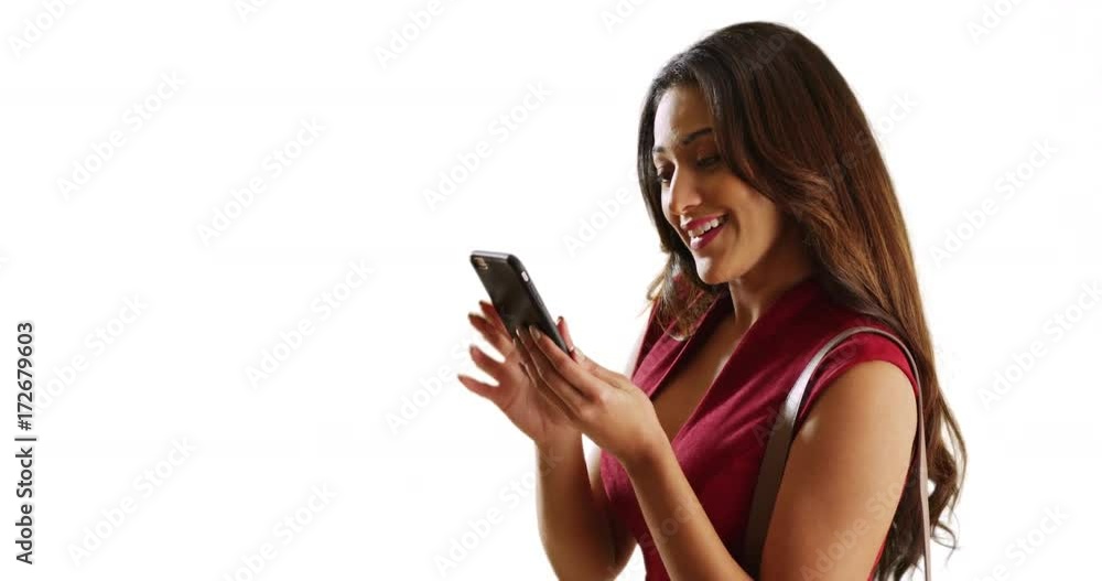 Attractive Latina female in sexy red dress taking a selfie with smart phone on white background with copyspace. Smiling woman dressed for a fun time taking a photo of herself in studio. 4k Attractive Latina female in sexy red dress taking a selfie with smart phone on white background with copyspace. Smiling woman dressed for a fun time taking a photo of herself in studio. 4k
