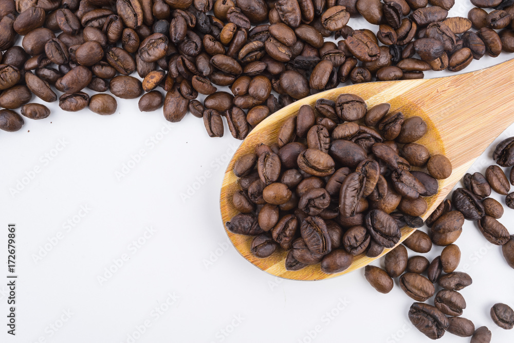 Concept roasted coffee beans in wooden ladle with isolated white background