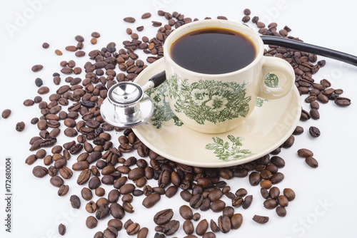 Concept roasted coffee beans, hot coffee and stethoscope isolated white background