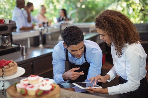 Male waiter and female waitress with digital tablet photo