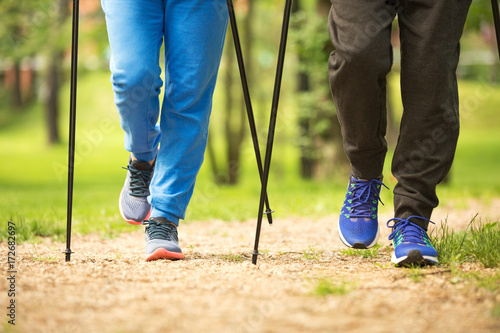 Slika na platnu Senior couple nordic walking in park