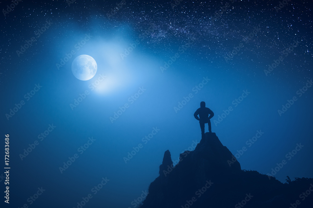 Fototapeta premium Silhouette of man standing on a cliffs edge