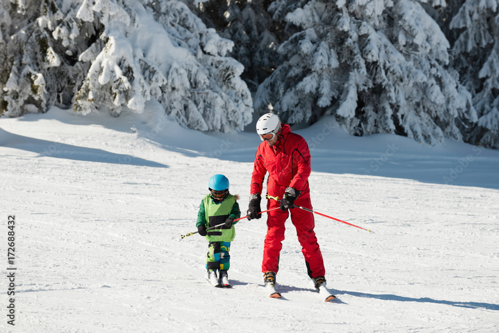 Little boy and ski trainer
