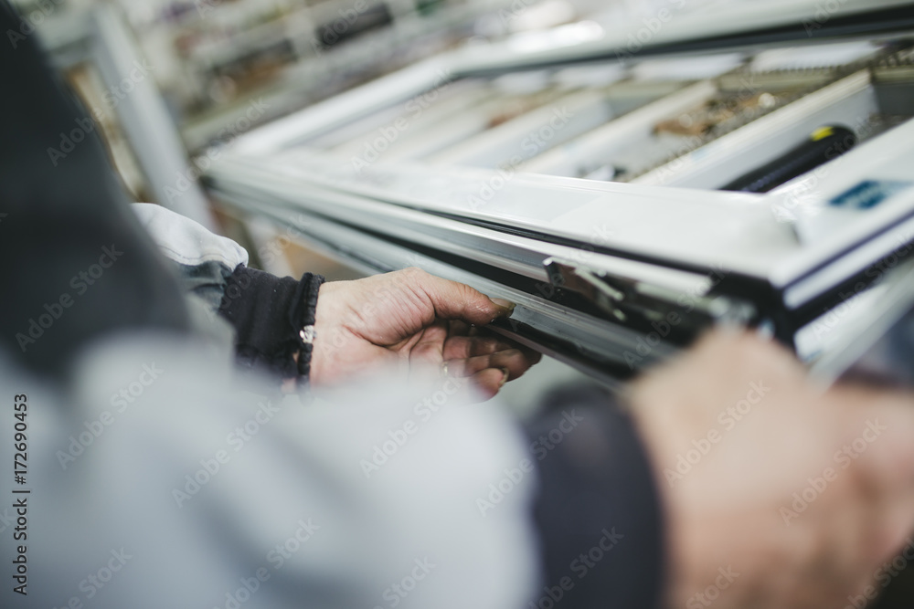 Manual worker assembling PVC doors and windows. Manufacturing jobs. Selective focus. Factory for aluminum and PVC windows and doors production. Manual worker assembling PVC doors and windows. Manufacturing jobs. Selective focus. Factory for aluminum and PVC windows and doors production.