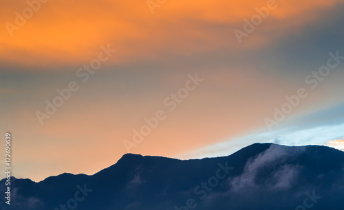 Colorful Sky and Clouds drifting over the forest mountain in evening time