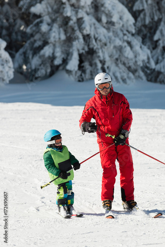 Ski instructor teaching little boy
