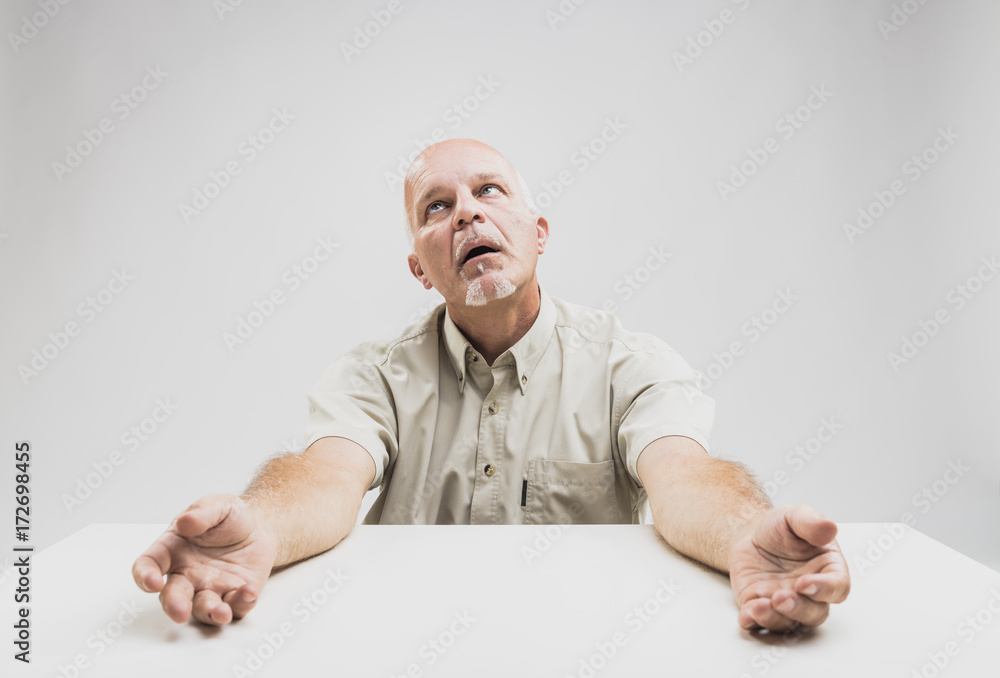 Stressed senior man looking up imploringly Stressed senior man looking up imploringly