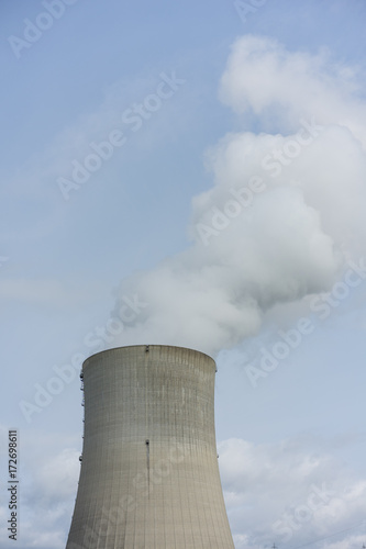 nuclear power plant chimney with condensation smoke on a cloudy day