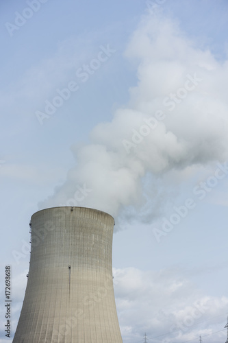 nuclear power plant chimney with condensation smoke on a cloudy day
