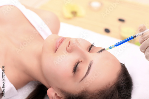 Woman gets injection in her face. Beauty woman giving injections. Young woman gets beauty facial injections in the cosmetology salon. Face aging injection. Aesthetic Medicine, Cosmetology