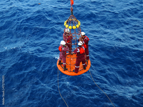 Workers are lifted by the crane to the offshore platform, Transfer crews by personal basket from the platform to crews boat