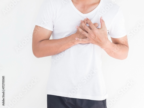 Young man has chest pain, heart attack, hands pressing on chest.
