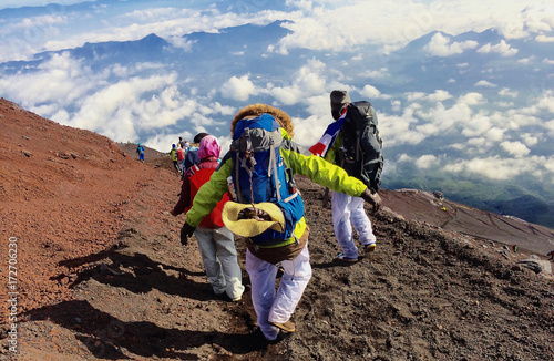 Guy with a travel backpack on the top of a boulder