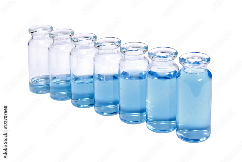 A row of phials with blue vaccine on white background A row of phials with blue vaccine on white background