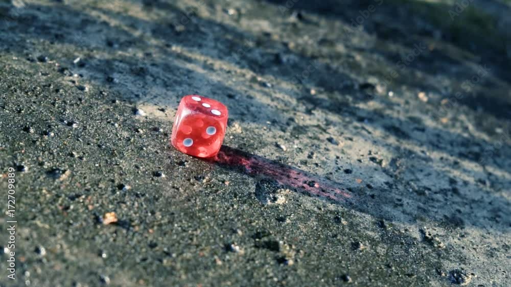 Red dice rolling on a concrete slab in slow motion Red dice rolling on a concrete slab in slow motion
