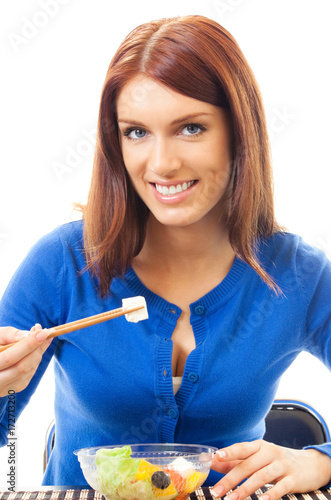 Cheerful woman eating salad, over white
