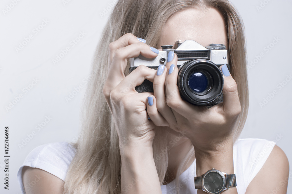Young beautiful woman taking a photo with a retro camera Young beautiful woman taking a photo with a retro camera