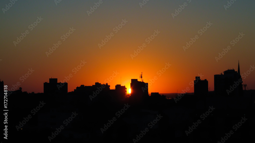 Silhouette of buildings against orange sunset in the city of Uruguaiana, Rio Grande do Sul, Brazil
