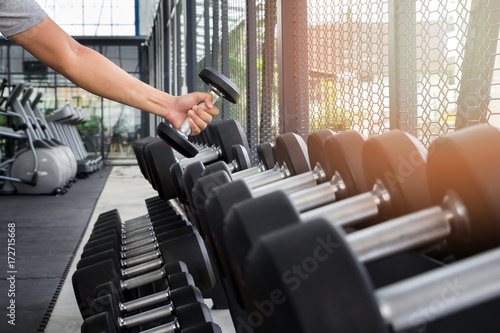 Athlete man training in the gym. A man lifting dumbbell