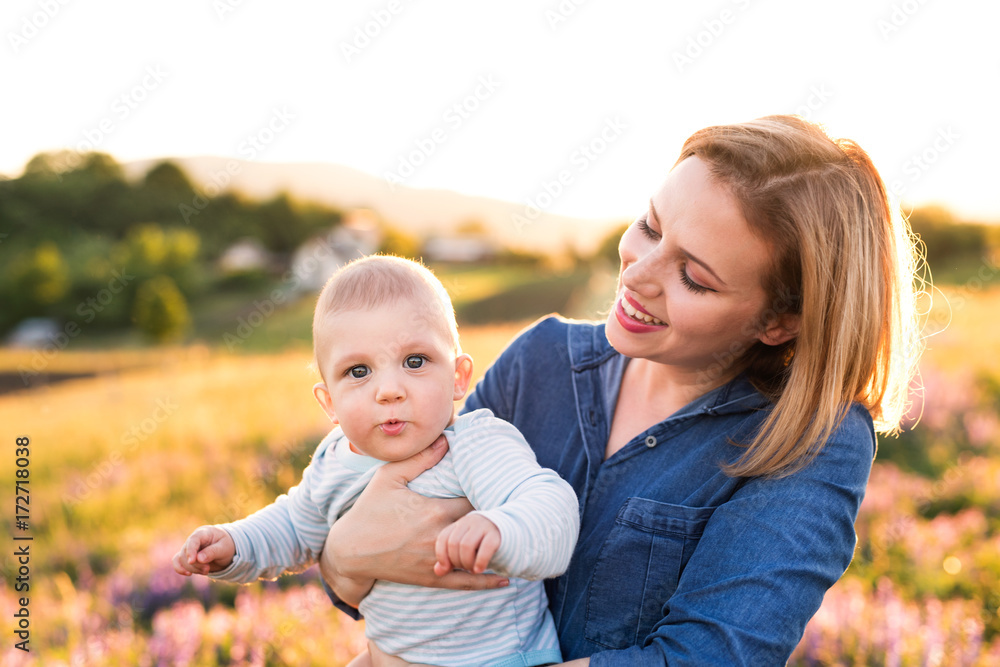 Young mother in nature with baby son in the arms. Young mother in nature with baby son in the arms.